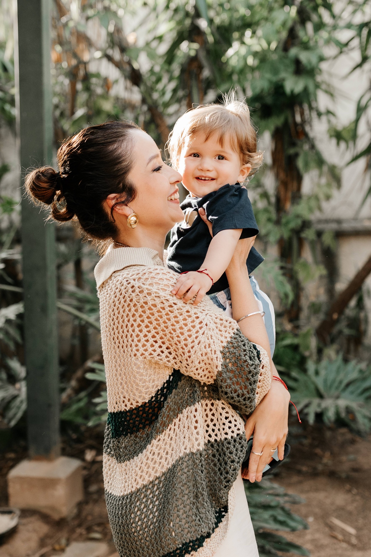 Mãe rindo com o filho pequeno no colo